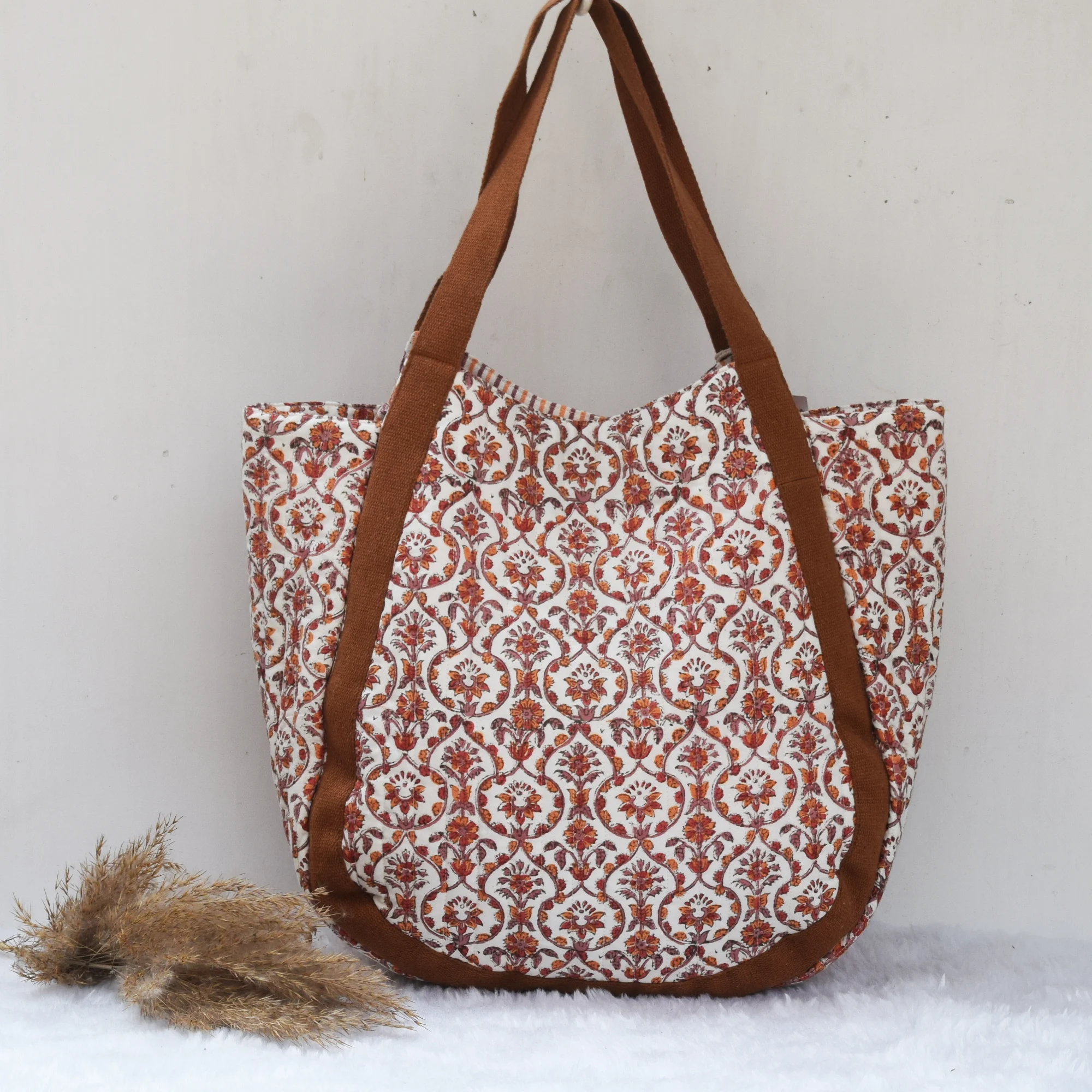 Brown and white floral block print cotton tote bag with thick brown shoulder straps, displayed on a white background