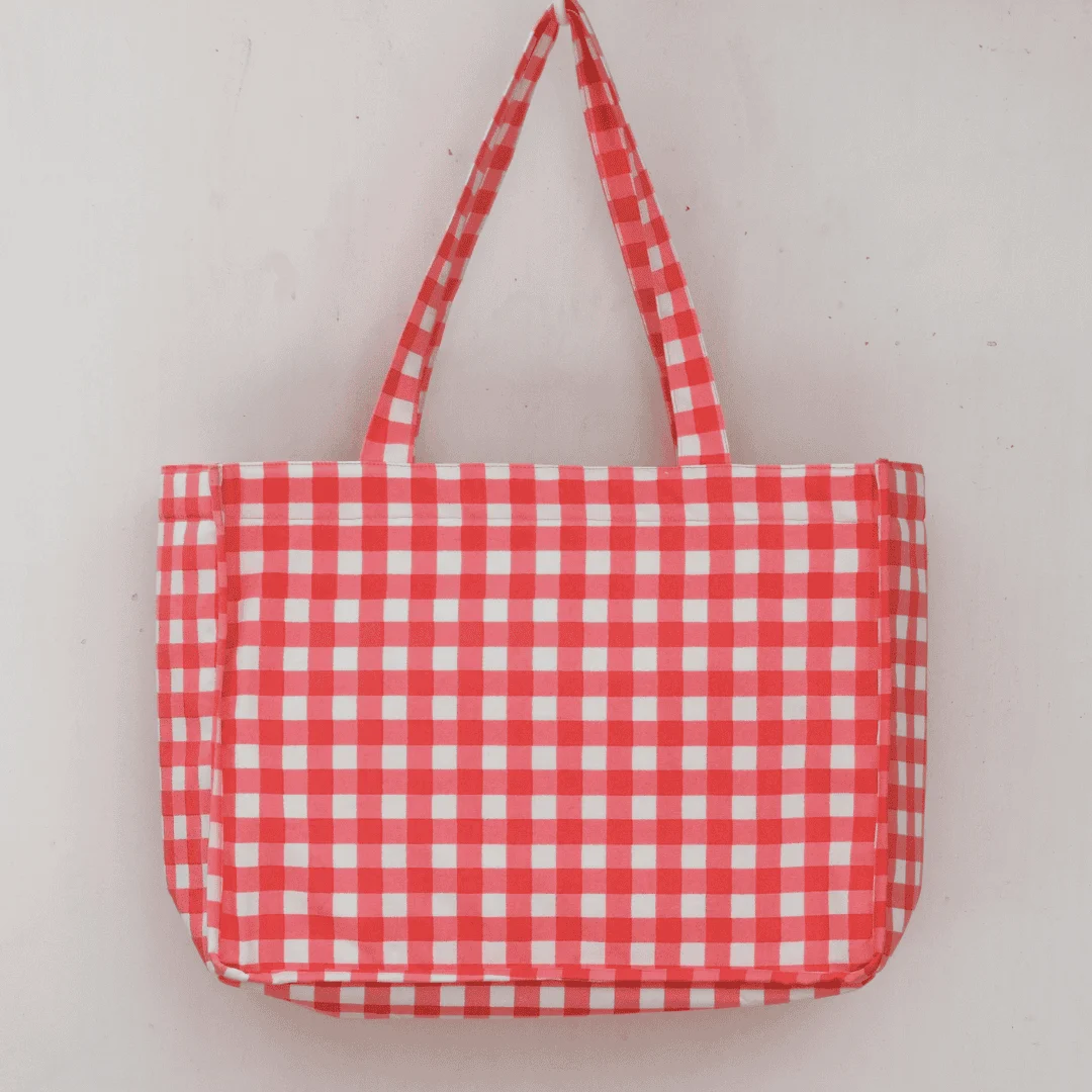 Pink and white gingham check cotton tote bag with soft handles, hanging on a white background